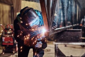 a man in welding gear welding a structure